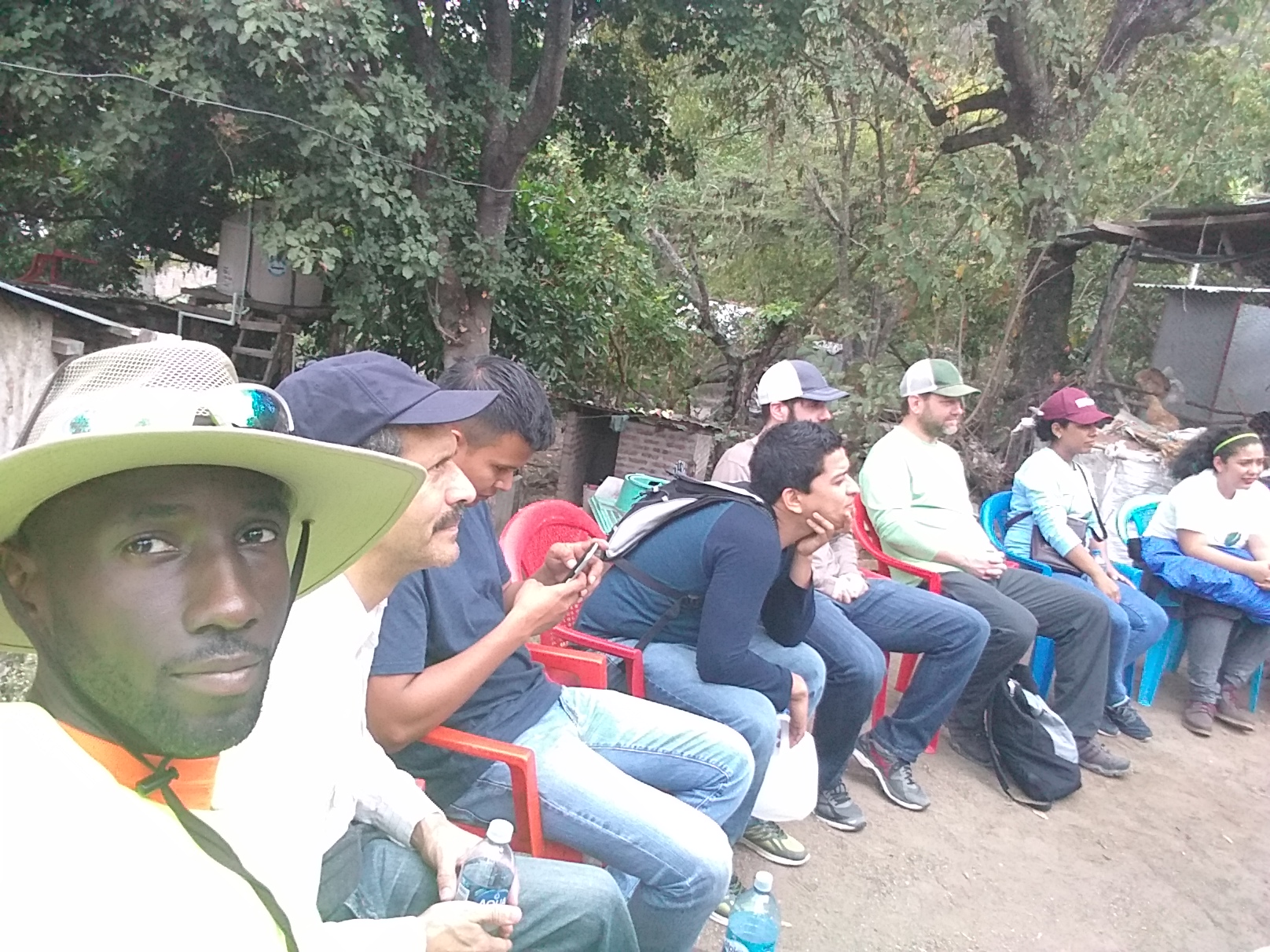 Marquis and a group seated outdoors during a community visit